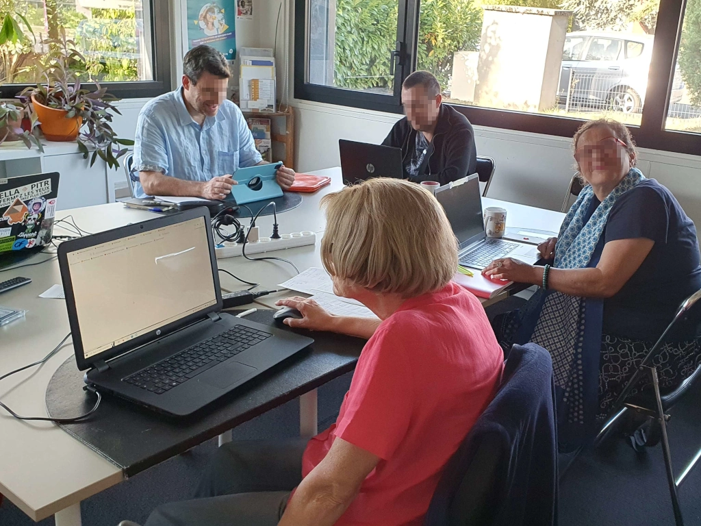 Quatre participants du PapyCamp assis devant leur ordinateur dans les locaux de Zoomacom.